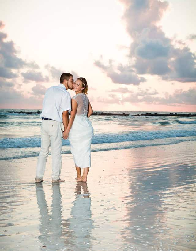 Couple at sunset on the beach by Cara DeHart Lewis Photography